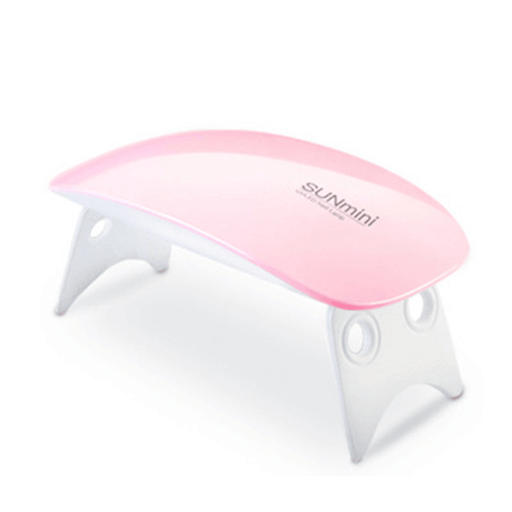 Pink SUNmini portable UV LED nail dryer lamp for gel polish manicure with folding legs on a white background.