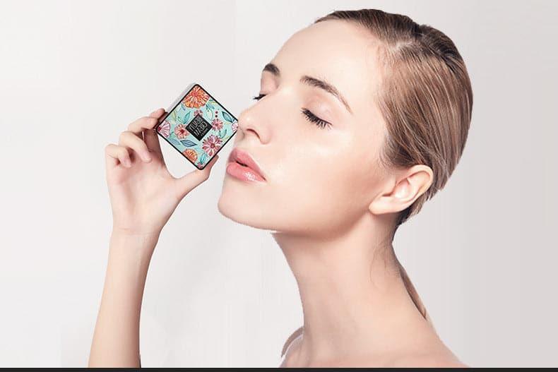 Model with glowing skin holding the floral Beauty Base Cream cushion compact foundation for a hydrating, flawless finish.