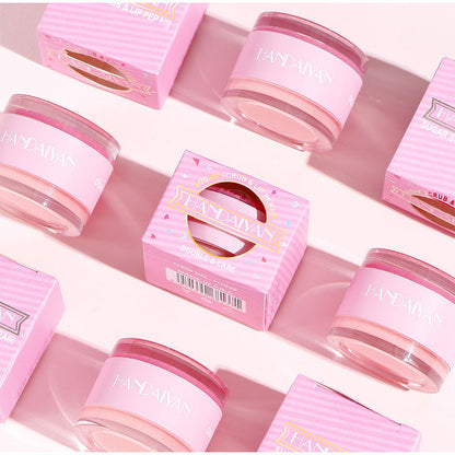 Handaiyan 2-in-1 lip scrub and moisturizing balm jars and pink striped boxes on a light pink surface.