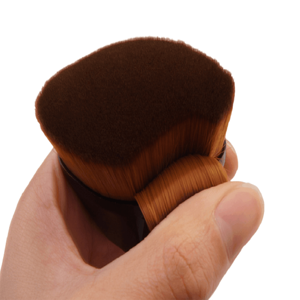 Close-up of dense, soft bristles on a hexagonal foundation makeup brush being held for a professional finish.