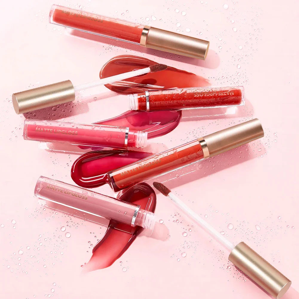 Luxe Glow Matte Lip Gloss Kit featuring six tubes and liquid swatches in red and pink shades on a pink background.