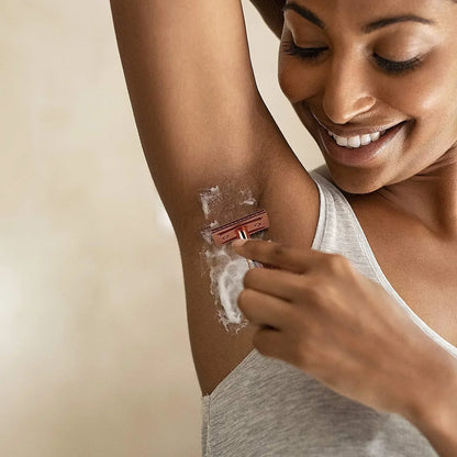 Woman using the SmoothShave rose gold eco-friendly safety razor for a smooth underarm shave with shaving foam.