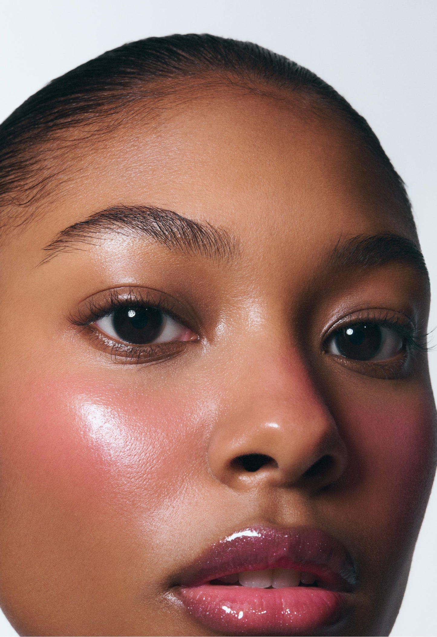 Model wearing Pocket Blush in Teacup, showing a dewy, glowy pink finish on cheeks and hydrating cream makeup on lips.