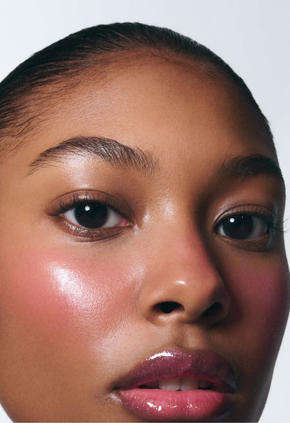 Model wearing Pocket Blush in Teacup, showing a dewy, glowy pink finish on cheeks and hydrating cream makeup on lips.